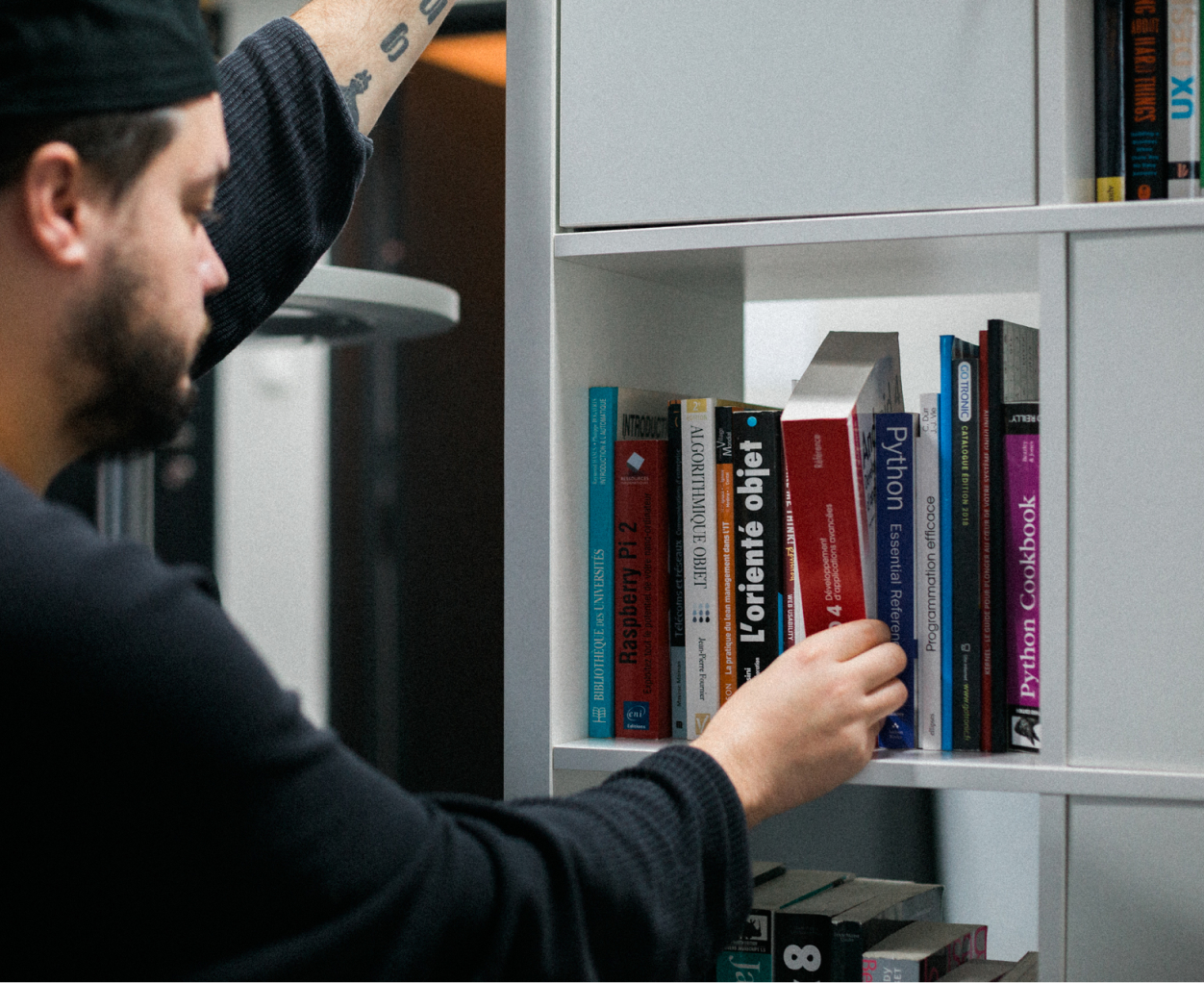 Main d'un membre de l'équipe prenant un livre